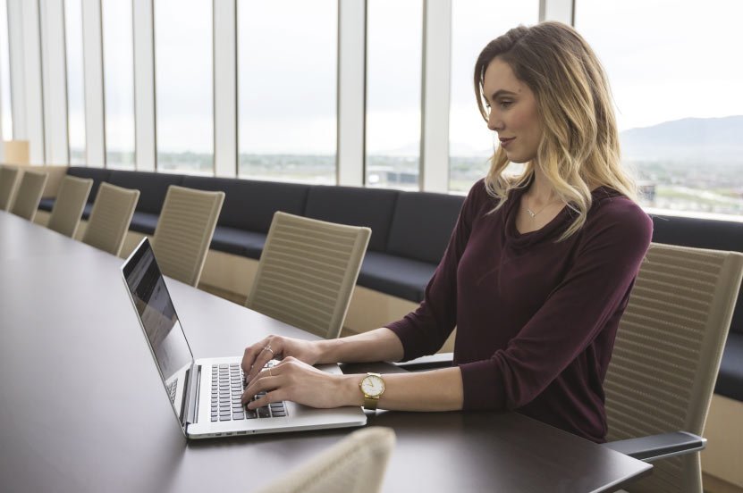 Person Working on Laptop in Conference Room